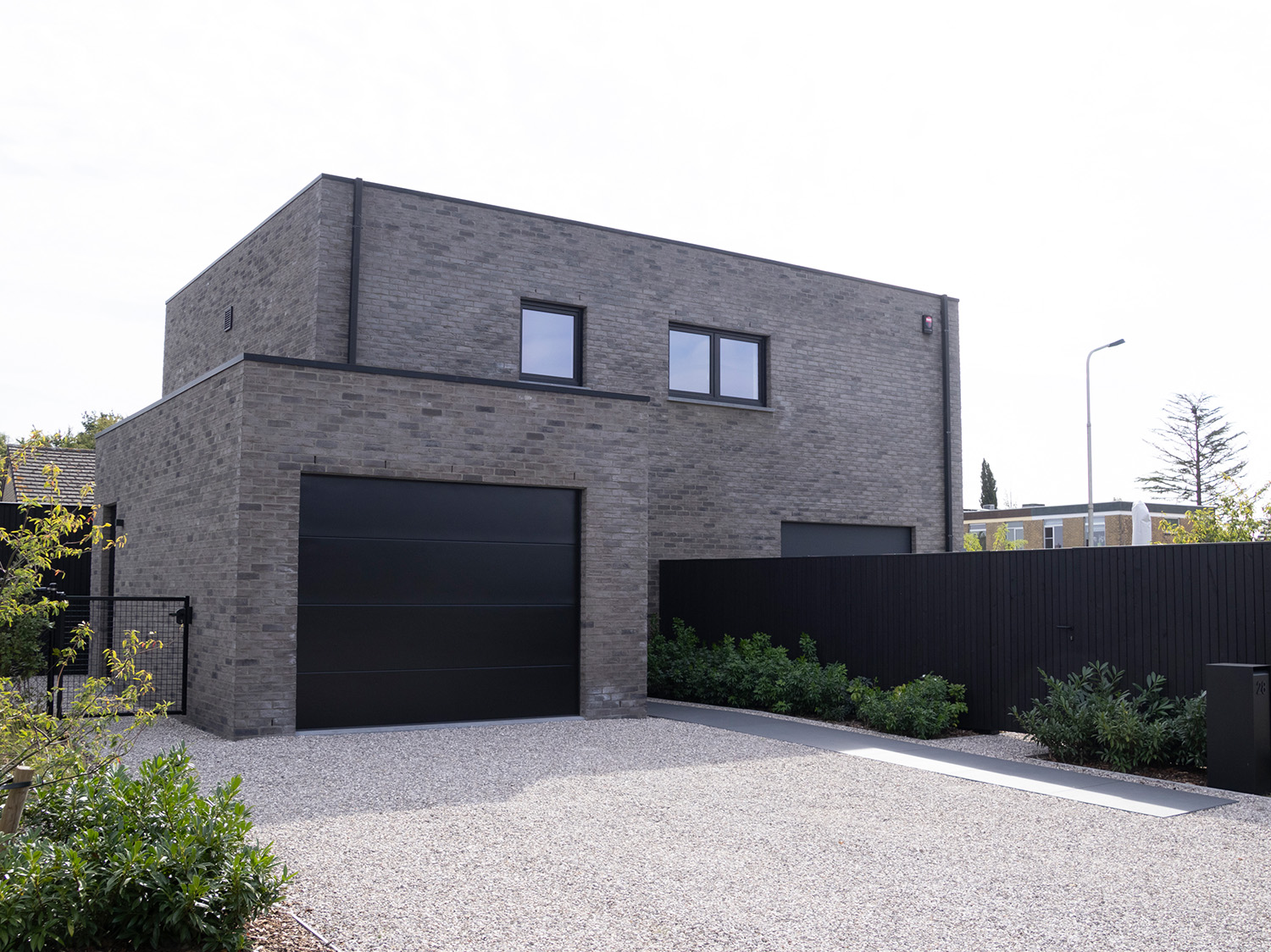 L-vormige woning met zwarte poort