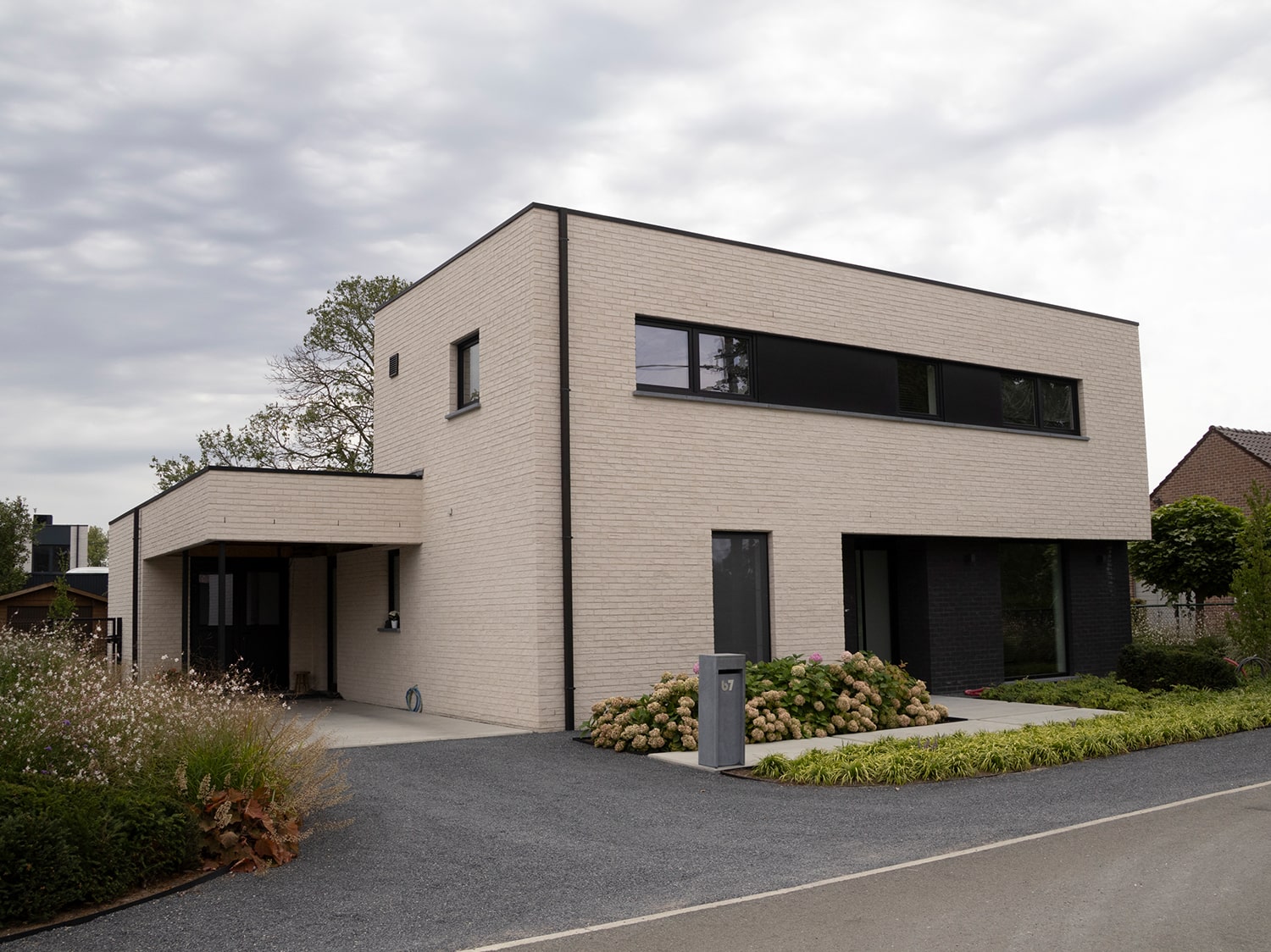 Voorgevel van moderne woning in Zaffelare met lichte gevelsteen en zwarte accenten