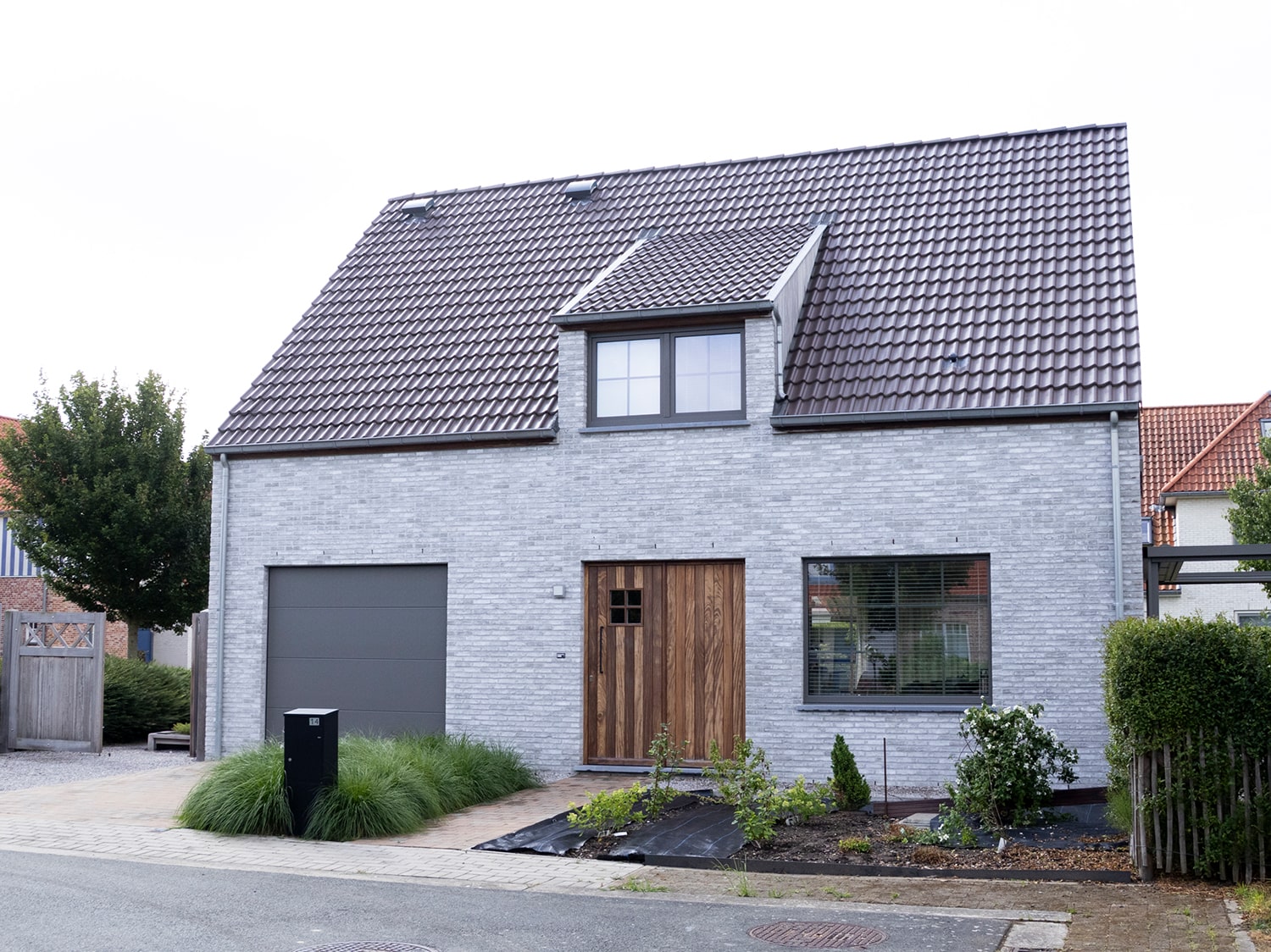 Detail van houten voordeur en gevelsteen in moderne woning