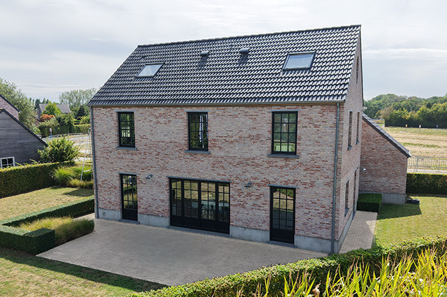 Façade arrière avec terrasse et jardin de la maison témoin Sibomat à Bierges