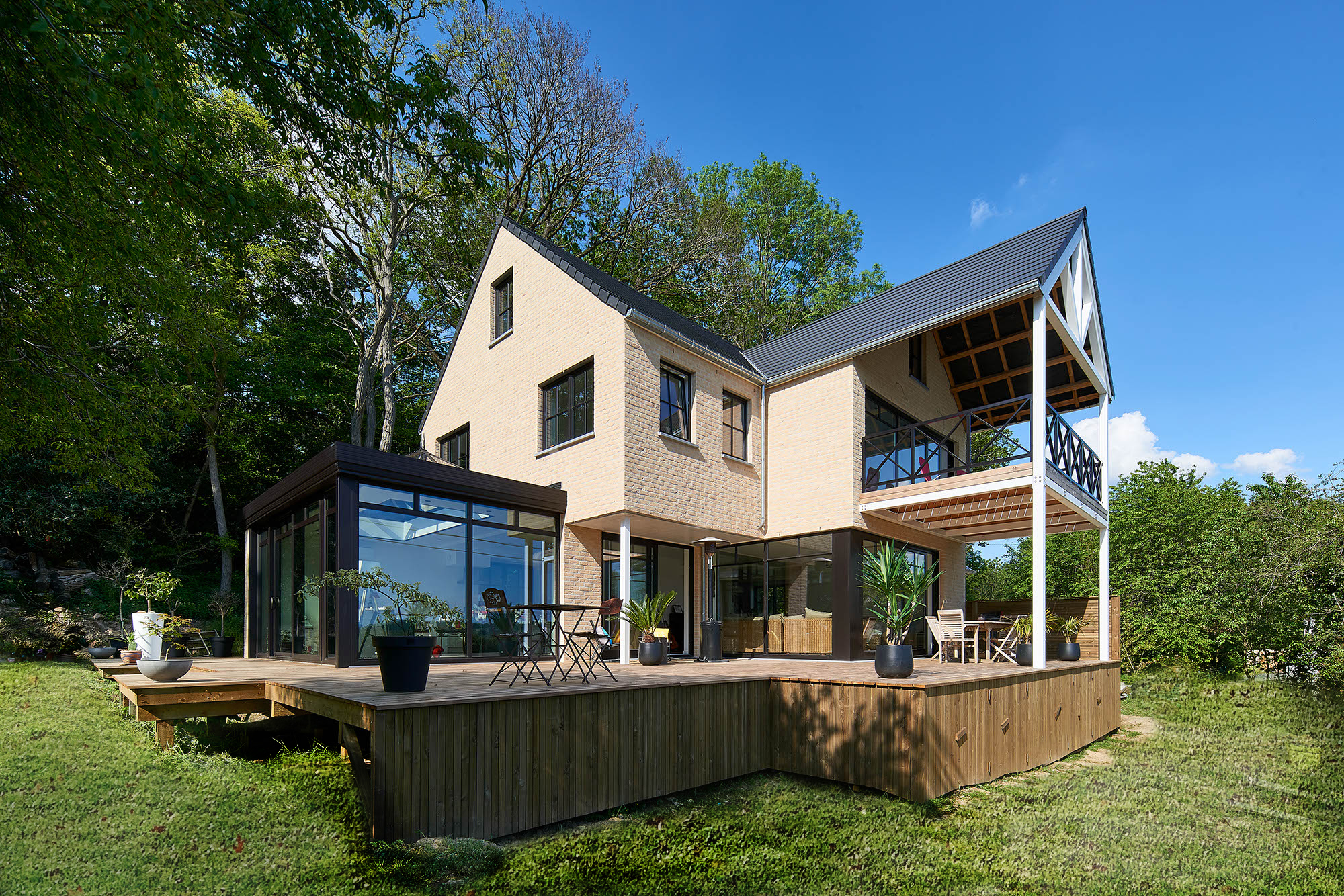 Maison classique avec briques claires et châssis noirs