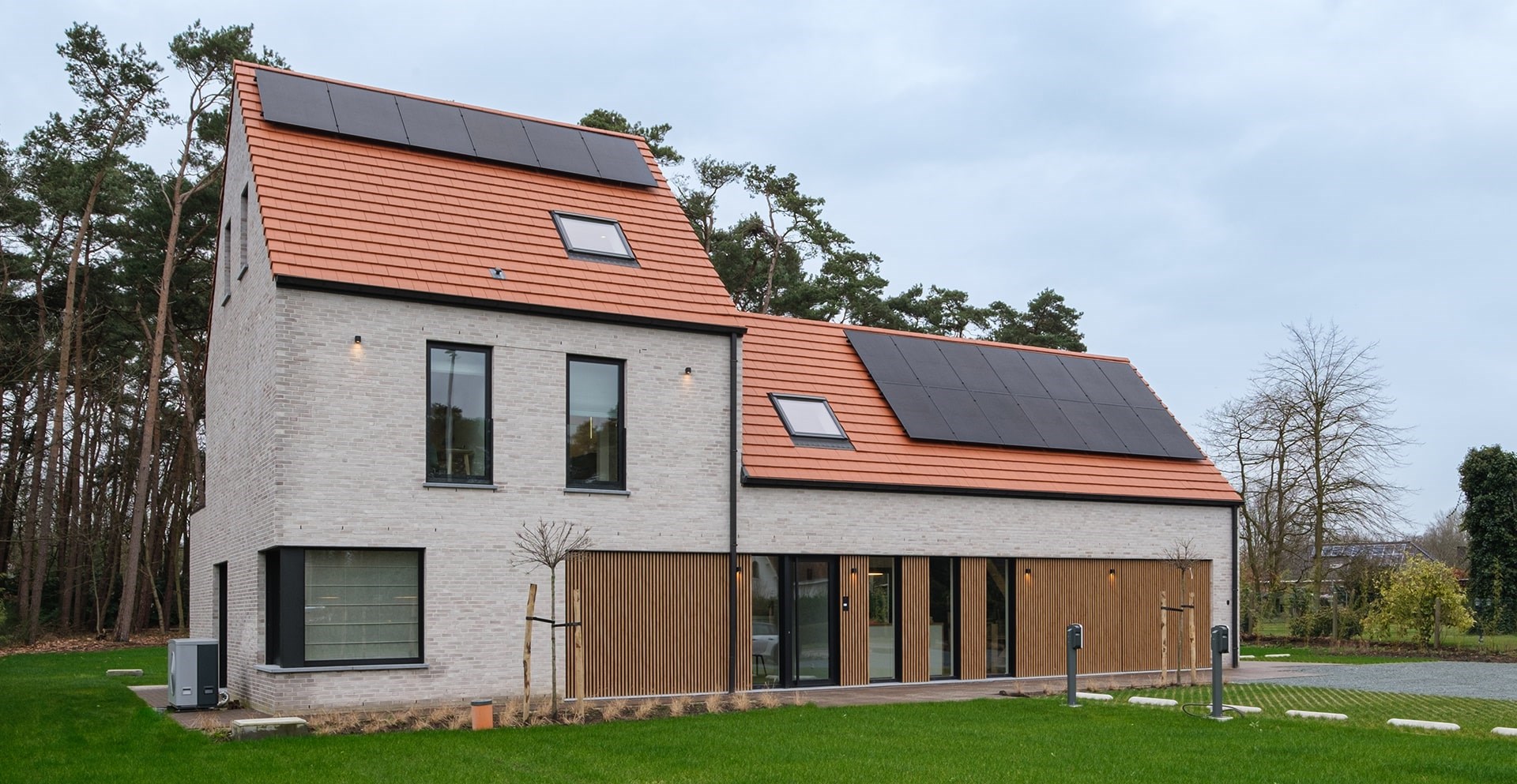 Construire une maison contemporaine avec panneaux solaires et toit rouge