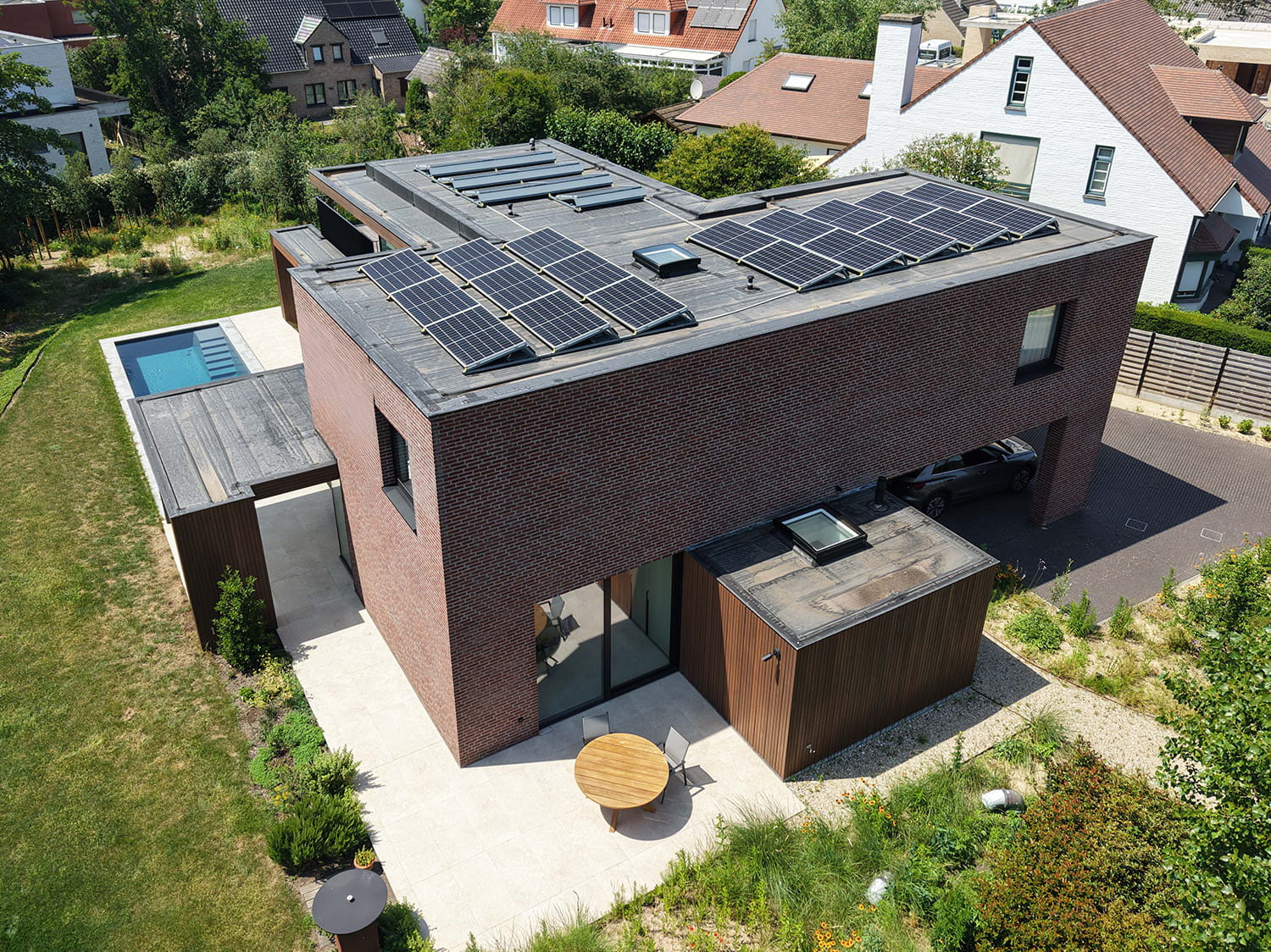 Luchtbeeld van moderne woning in Oostduinkerke met zonnepanelen, zwembad en overdekte terrassen