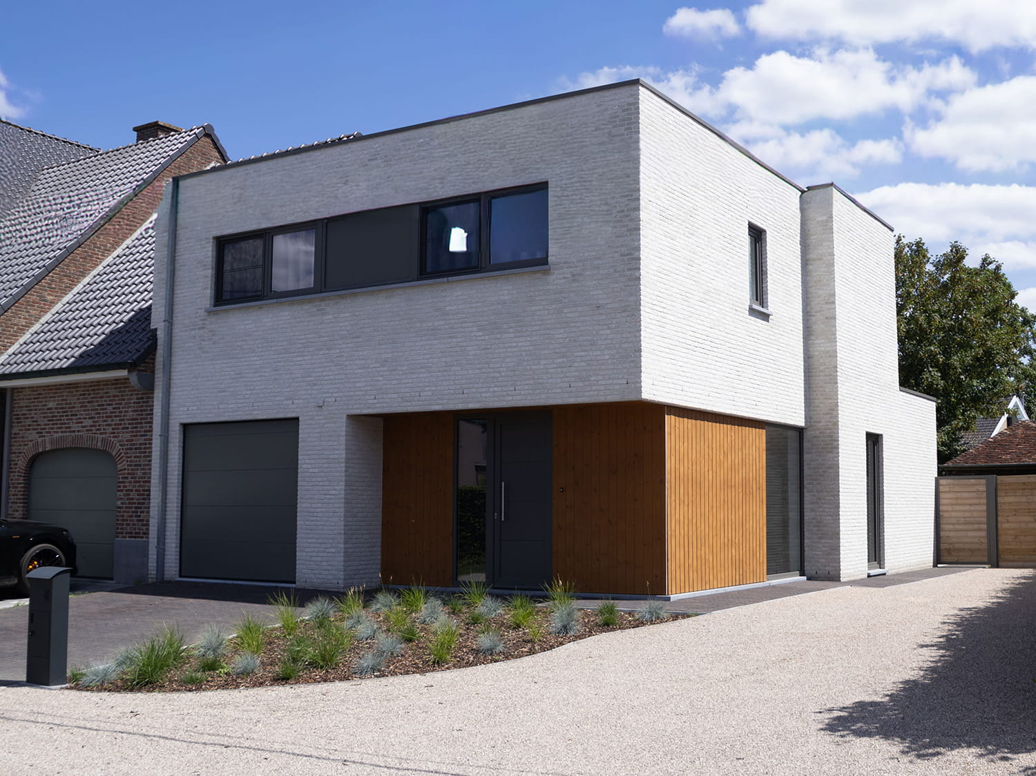 Moderne halfopen bebouwing in Lievegem met witte gevelsteen en houten gevelbekleding