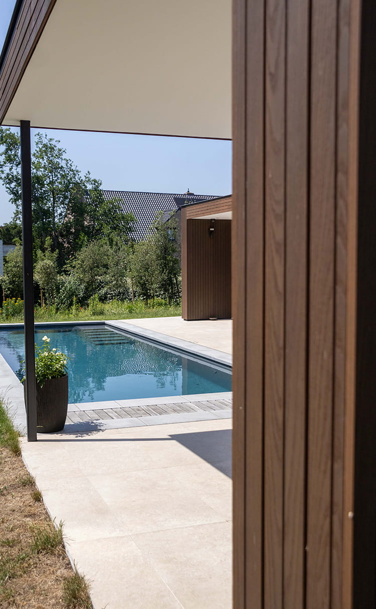 Zicht op het zwembad en de Hotwood gevelbekleding van deze moderne woning in Oostduinkerke